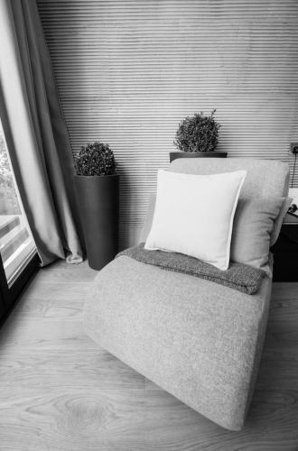a bed with a pillow and two plants in a room at Boutique Hotel Valsabbion in Pula