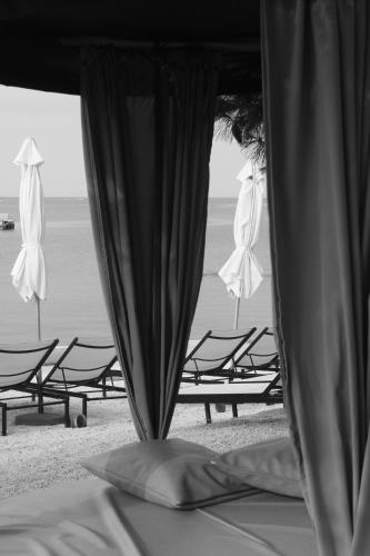 a group of chairs and umbrellas on the beach at Boutique Hotel Valsabbion in Pula