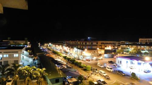 a city at night with cars parked in a parking lot at Hotel Ocean in Lahad Datu