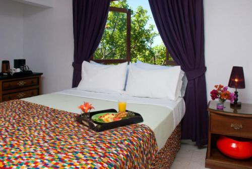 ein Schlafzimmer mit einem Bett und einem Tablett mit einer Kerze darauf in der Unterkunft Mynt Retreat Bed & Breakfast in Montego Bay