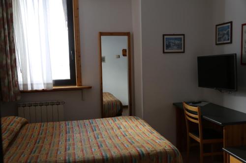 Un pat sau paturi într-o cameră la Hotel Dolomiti
