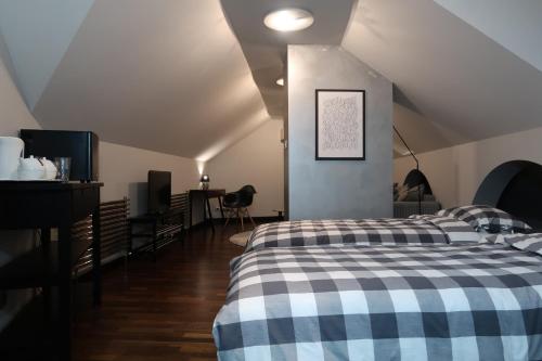 a bedroom with a bed with a checkered blanket at Arkada Wadowice in Wadowice