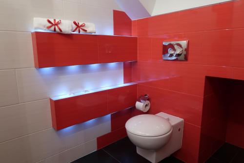a red bathroom with a toilet and red walls at Arkada Wadowice in Wadowice