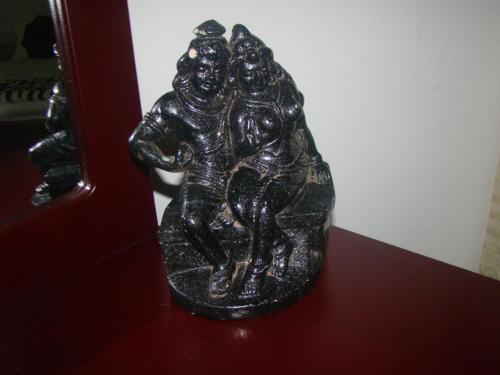 a bronze statue of two men on a wall at Thuruliya Residence in Sigiriya