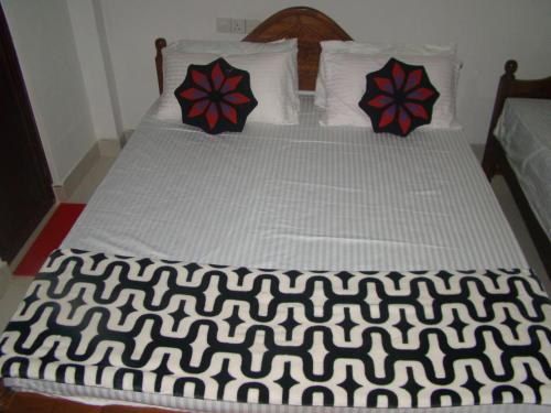 a bed with black and white sheets and pillows at Thuruliya Residence in Sigiriya