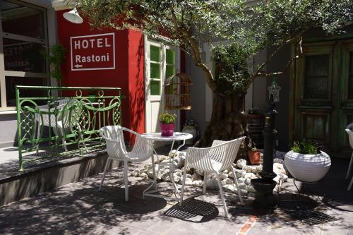 a group of chairs and a table in front of a tree at Hotel Rastoni - Helvetia in Platamonas