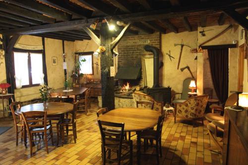 un restaurant avec des tables, des chaises et une cuisinière dans l'établissement La Maréchalerie, à Monthodon