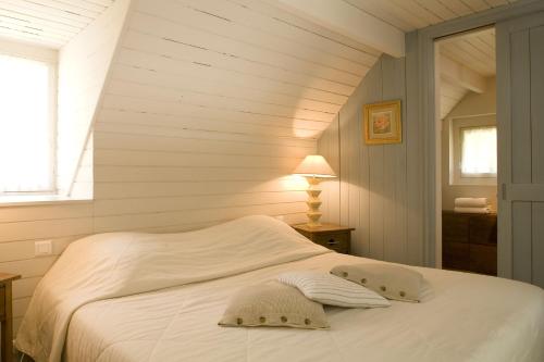 un lit blanc dans une chambre avec une fenêtre dans l'établissement Cottages De La Bretesche, à Missillac