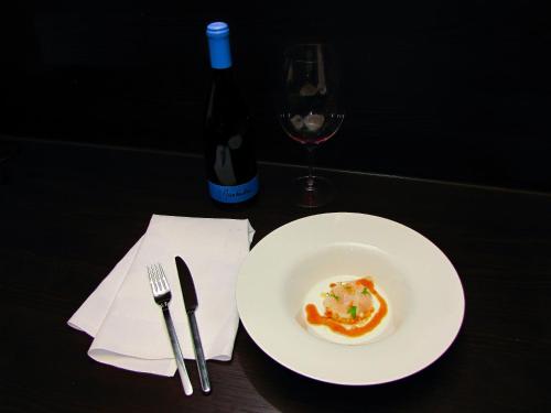 a plate of food and a bottle of wine on a table at DAS TANN rooms & wine in Thale
