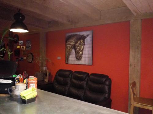 a room with a couch and a picture of a horse on the wall at Le Relais du Moulin in Gedinne