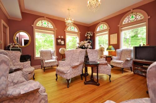 a living room with chairs and a table and a tv at Braeside Country Inn in Pictou