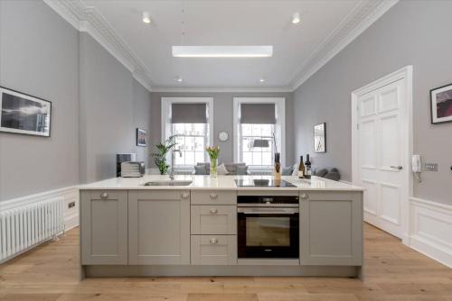 a large kitchen with a sink and a stove at JOIVY Spacious Apartment close to Princes Street in Edinburgh