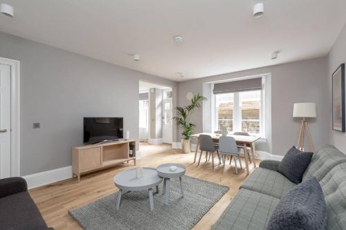a living room with a couch and a table at JOIVY Luxurious Home near Haymarket Station in Edinburgh