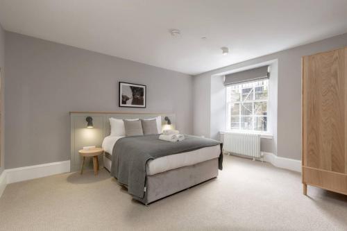 a bedroom with a large bed and a window at JOIVY Luxurious Home near Haymarket Station in Edinburgh