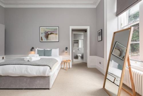 a bedroom with a bed and a mirror at JOIVY Spacious Apartment close to Princes Street in Edinburgh