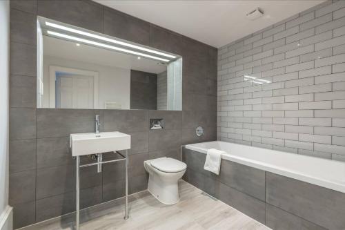 a bathroom with a sink and a toilet and a bath tub at JOIVY Luxurious Home near Haymarket Station in Edinburgh