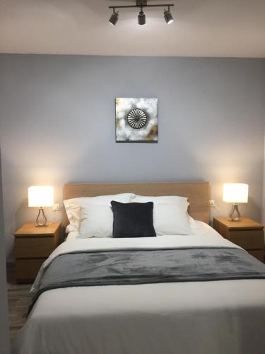 a bedroom with a large bed with two lamps at Luxury beachfront apartment in Benalmadena Costa in Benalmádena