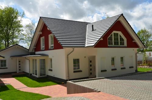 ein Haus in Rot und Weiß in der Unterkunft Strandhus Sellin - Apt. 02 in Ostseebad Sellin