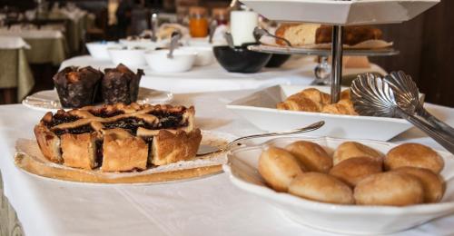 a table topped with plates of bread and pastries at Hotel Aganoor in Castiglione del Lago