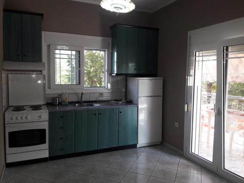a kitchen with green cabinets and a white refrigerator at Villa Eleni in Ofrínion