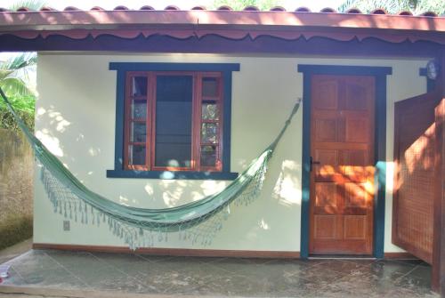 a small house with a hammock on the side of it at Pousada Arte de Viver in Lumiar