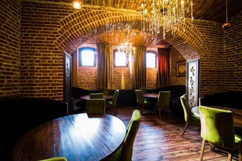 a room with tables and chairs and a brick wall at Hotel 5 Continents in Craiova