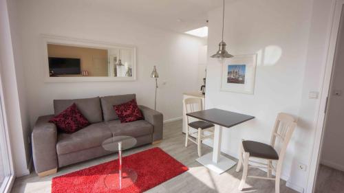 a living room with a couch and a table at Hotel Stadt Cuxhaven in Cuxhaven