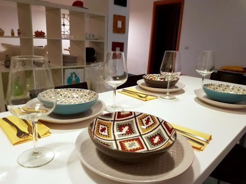 una mesa con tazones y copas de vino. en SuitHome Trecchina, en Trecchina