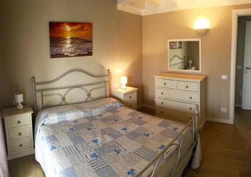 1 dormitorio con cama, tocador y espejo en Residence Elegance, en Porto Pino