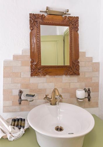 a bathroom sink with a mirror on the wall at Kalderimi Residencies in Astypalaia Town
