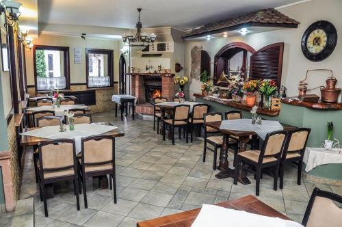 un restaurante con mesas y sillas y una chimenea en Pensiunea Casa Albă, en Ghimbav
