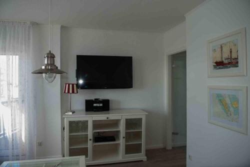 a living room with a flat screen tv on a wall at Hotel Stadt Cuxhaven in Cuxhaven