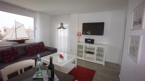 a living room with a couch and a tv at Hotel Stadt Cuxhaven in Cuxhaven