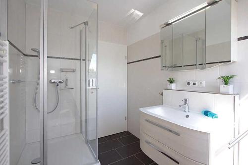 a white bathroom with a shower and a sink at Wohnung Albatros im Haus Wassermann in Neu Gaarz