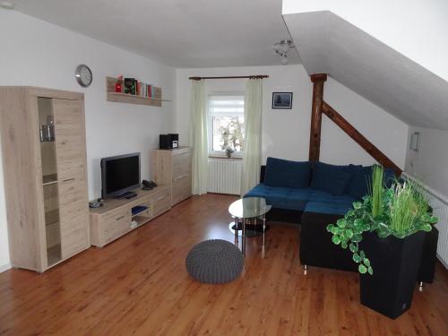 a living room with a blue couch and a tv at Gästehaus Eberle in Oberstaufen