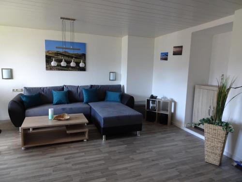 a living room with a blue couch and a table at Gästehaus Eberle in Oberstaufen