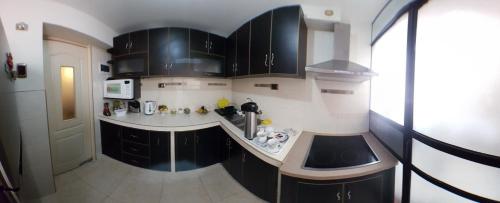a kitchen with black cabinets and a counter top at Cusco Mágico 4 - Departamento Las Torres Kayser in Cusco