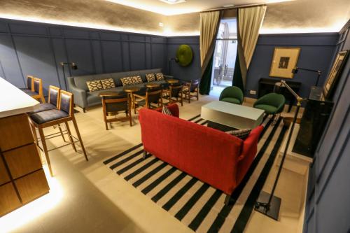 a living room with a red couch and chairs at Parador de Lleida in Lleida