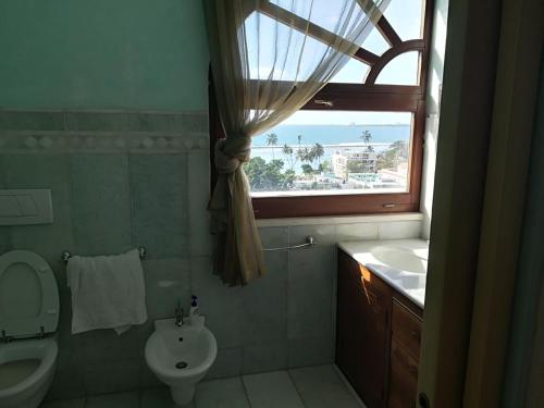 a bathroom with a toilet and a sink and a window at Villa Florencia in Boca Chica