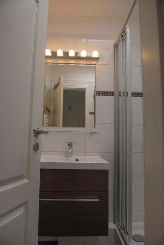 a bathroom with a sink and a mirror at Hotel Stadt Cuxhaven in Cuxhaven