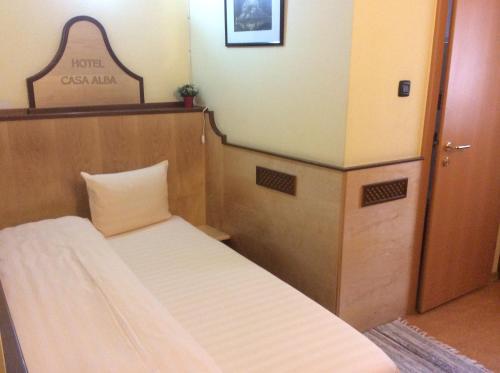 a small room with a bed and a sign on the wall at Pensiunea Casa Albă in Ghimbav