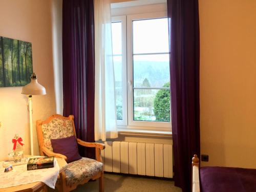 a room with a window and a chair and a table at Landhotel Hubertus in Unterelsbach