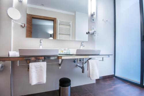 a bathroom with a sink, toilet and shower stall at Parador de Lleida in Lleida
