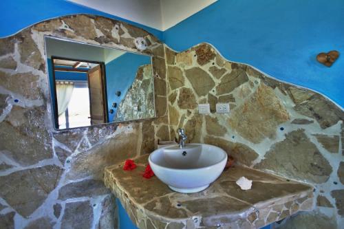 a stone bathroom with a sink and a mirror at B&B El Mirador al Mar in Sosúa