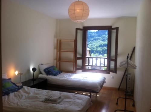 エル・プエヨ・デ・ハカにあるVistas Espectacularesのベッド2台と窓が備わる客室です。