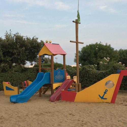 a playground with a slide in the sand at Hotel Italy in Bibione