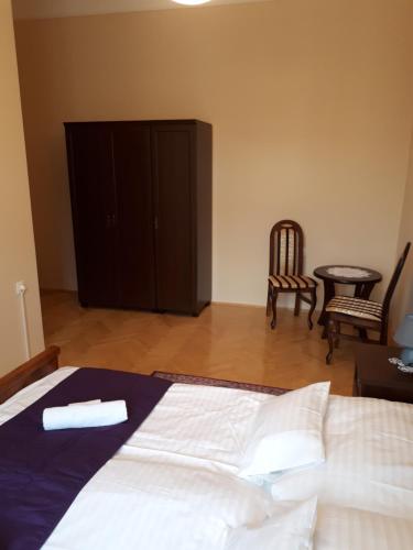 セゲドにあるCsanabella Houseのベッドルーム1室(ベッド1台、テーブル、椅子付)