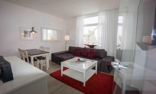 a living room with a couch and a table at Hotel Stadt Cuxhaven in Cuxhaven