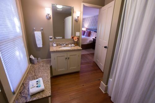 a bathroom with a sink and a bathroom with a bed at Gay Street Inn in Washington, Virginia