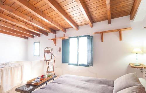 a bedroom with wooden ceilings and a bed and a window at Casa Rural Sierra de Huelva in Aroche